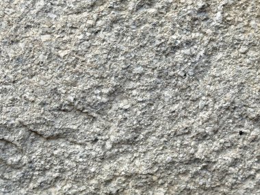 İnce çatlaklar ve çakıl taşları desenleriyle detaylandırılmış gri taş dokusu.