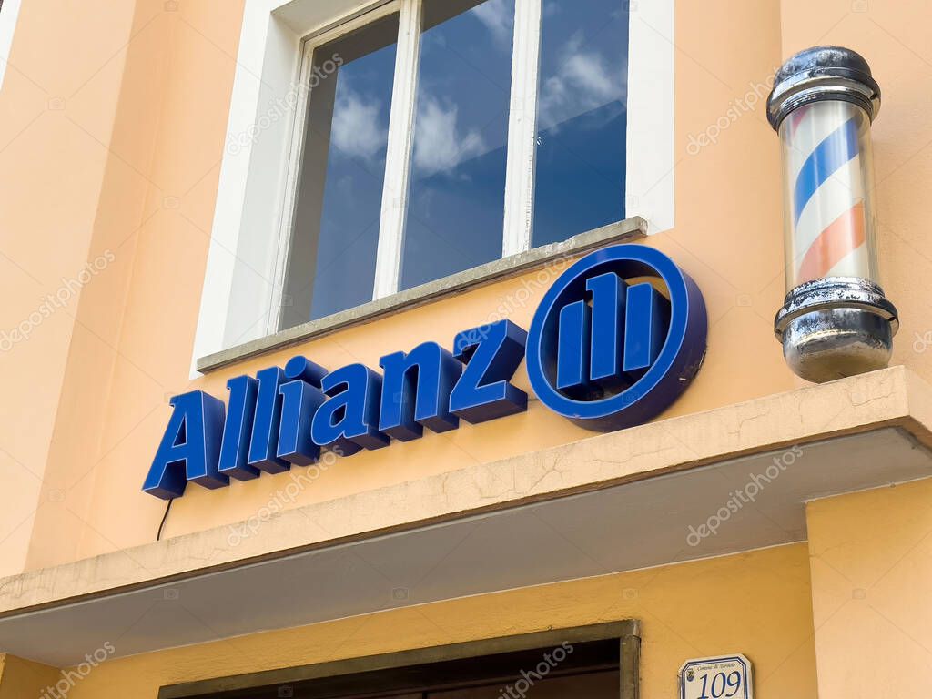 Allianz sign on cream-walled building exterior with barber pole.