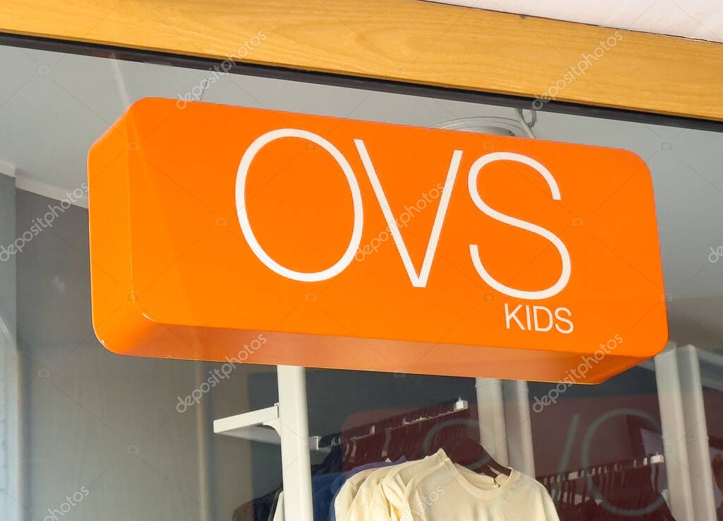 Ovs kids store signage on orange background in retail setting.