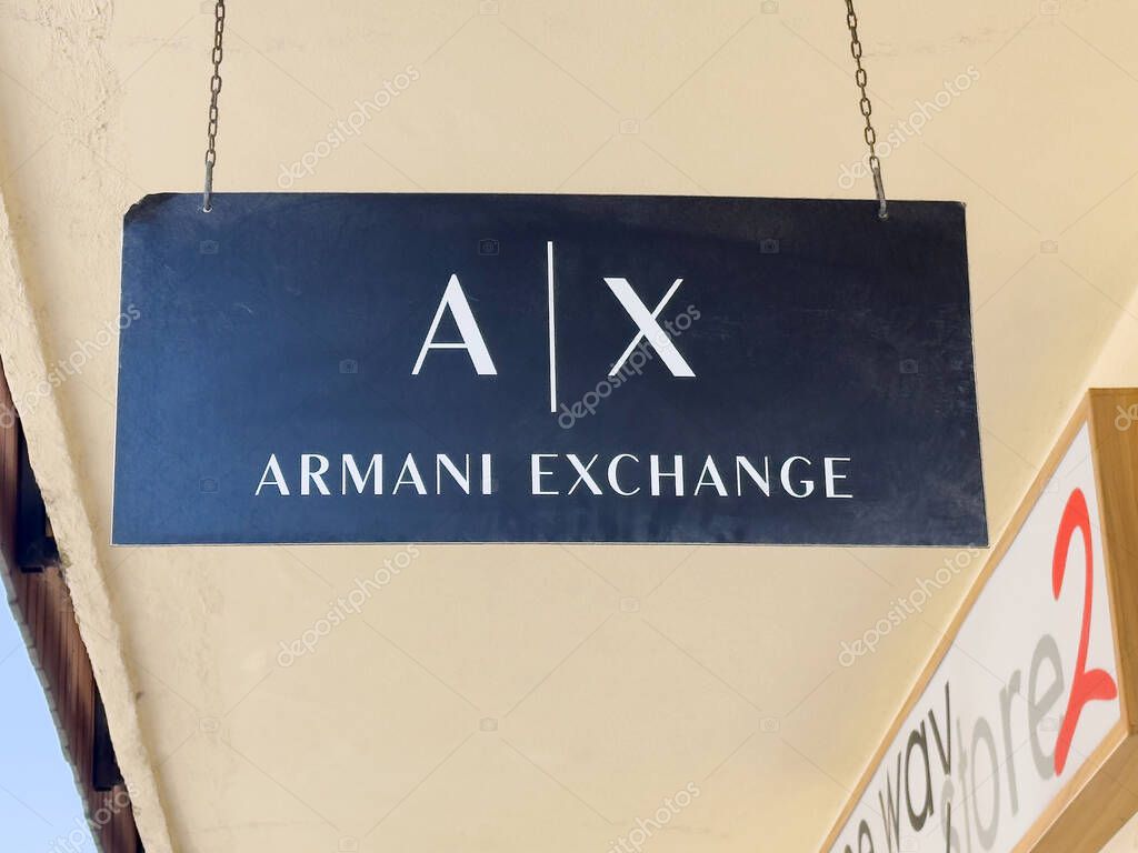 Armani exchange store sign hanging outdoors in urban shopping area.