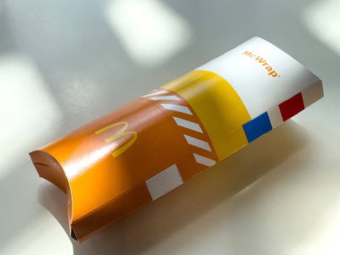 McDonald 'ın beyaz arka plandaki güneş ışığı gölgeli McDonald kutusunu boşalt.
