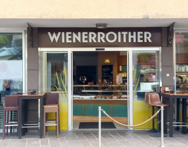 Açık hava oturma ve hoş geldin girişi olan modern bir kafe..