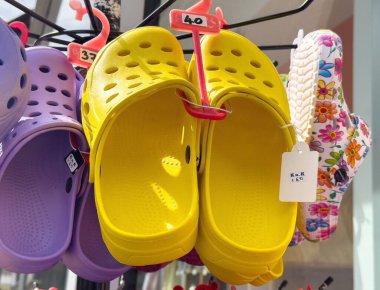 Mağazada renkli timsah sandaletleri sergileniyor.