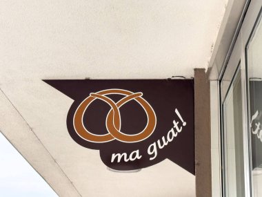 Ma guat pastanesi tabelası üzerinde kahverengi simit amblemi var..