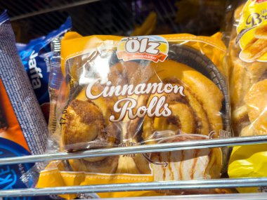Süpermarket koridorunda paketlenmiş tarçın ruloları sergileniyor.