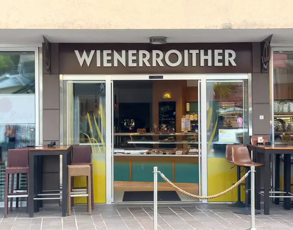 Açık hava oturma ve hoş geldin girişi olan modern bir kafe..