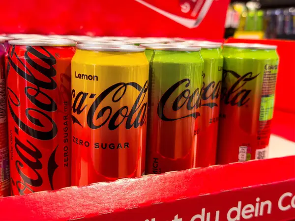 Süpermarket vitrininde limon ve limon aromalı çeşitli kola kutuları..