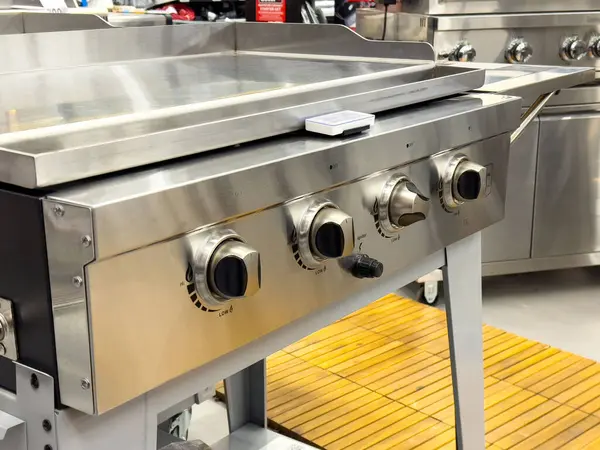 Mutfak galerisinde sıcaklık kontrol düğmeleri olan paslanmaz çelik üstü ızgara..