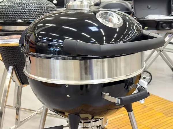 Modern kömür ızgarası açık havada pişirme vitrininde ve parlak siyah kaplamalı..