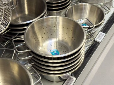Mutfak gereçleri vitrininde yığılmış metal kolonyalılar.