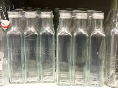 Vitrinde beyaz kapaklı boş cam şişeler.