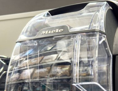 Depodaki Miele elektrik süpürgesi şeffaf toz kabını gösteriyor.