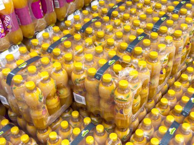 Bir markette plastik ambalajda istiflenmiş portakal suyu şişeleri..