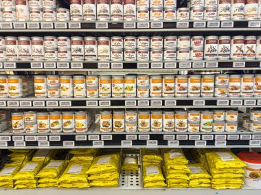 Marketin rafında sebze, baharat kavanozu ve çorba karışımı paketler var..