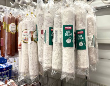 Market et reyonunda asılı çeşitli paketlenmiş salam seçimi.