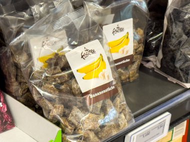 Rafta sergilenen şeffaf ambalajlı muz parçaları.