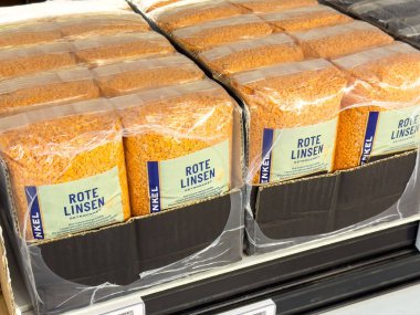 Market koridorunda rafta duran paketlenmiş kırmızı mercimek..