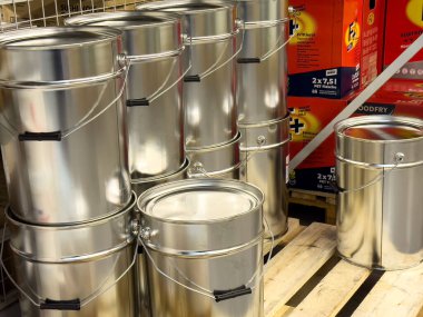 Hırdavatçıdaki metal boya kovaları paletin üzerine istiflenmiş..