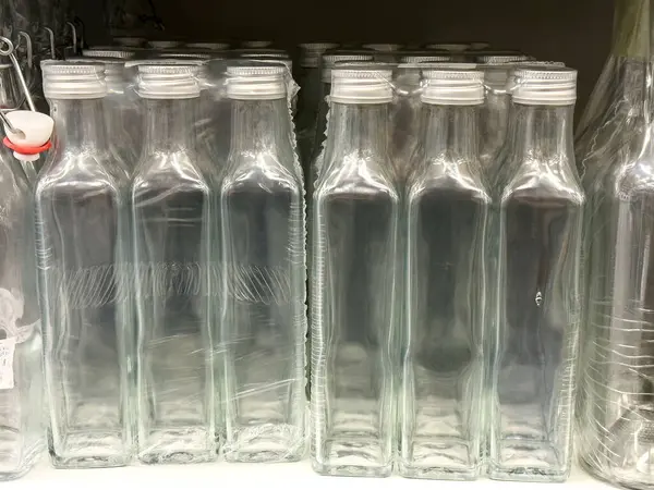 Vitrinde beyaz kapaklı boş cam şişeler.