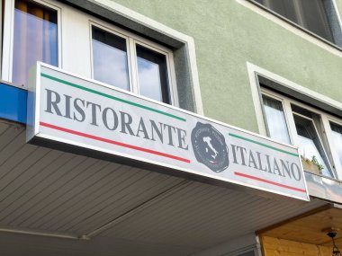 Dış bina üzerinde kırmızı ve yeşil çizgili İtalyan restoranı tabelası.
