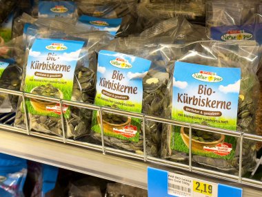 Süpermarketin rafındaki organik kabak tohumları rosto ve tuzlu çeşitlerle birlikte..