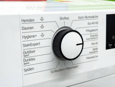 Modern çamaşır makinesinin kontrol düğmesi ve ayarları paneline yakın çekim.