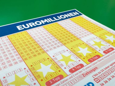 Yeşil yüzey üzerinde rakamlar ve yıldızlarla Euromillion piyango bileti.