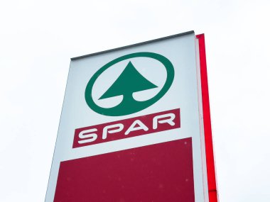 Açık gökyüzüne karşı yeşil ağaç logosu olan spor mağazası tabelası.