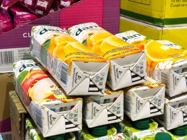 Süpermarket koridorunda yığılmış çeşitli meyve suyu kutuları..