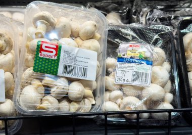 Markette paketlenmiş beyaz mantarlar sergileniyor.