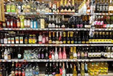 İçki dükkanlarının raflarında çeşitli şarap ve içki şişeleri var..