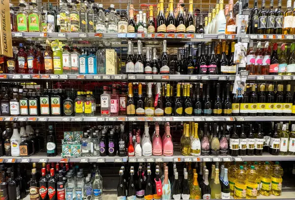 İçki dükkanlarının raflarında çeşitli şarap ve içki şişeleri var..