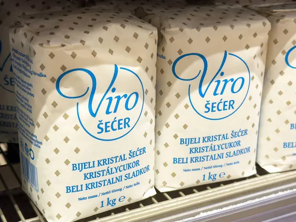 Market rafında paketlenmiş beyaz şeker torbaları.