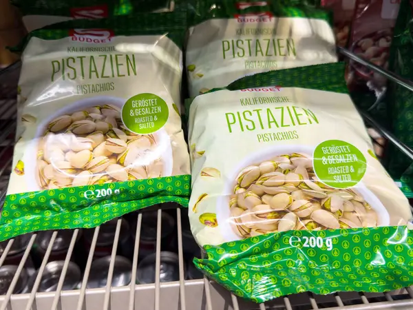 Raftaki yeşil ambalajda kavrulmuş tuzlu şam fıstığı..