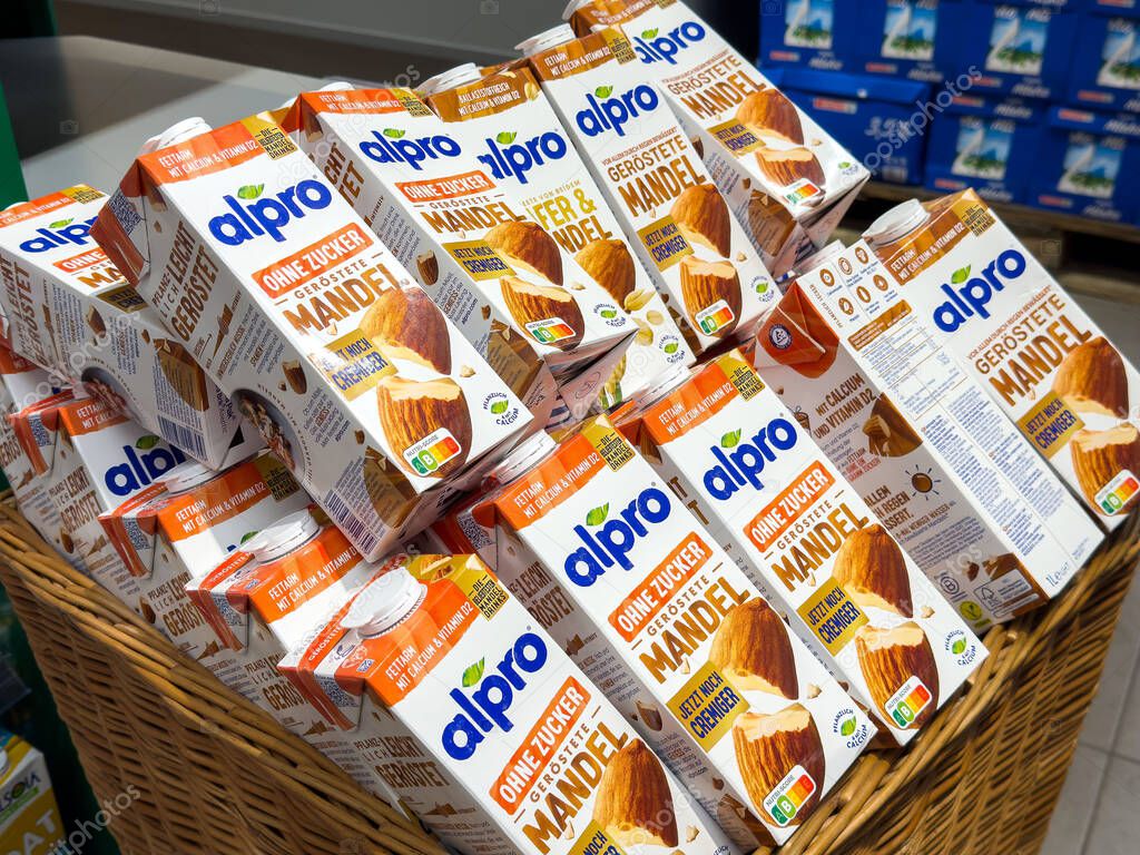Almond milk cartons displayed in store shelf basket with organic labeling.