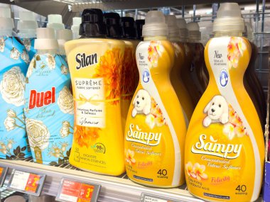 Süpermarket rafında renkli kumaş yumuşatıcıları ve çiçek tasarımları..