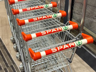 Mağaza girişine turuncu saplı spor arabaları dizilmiş..