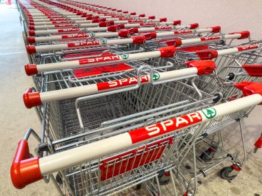 Markette kırmızı saplı düzenli alışveriş arabaları var..