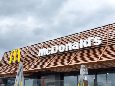 Modern McDonald 's restoranında bulutlu bir gün. Dışında ikonik altın kemerler var..
