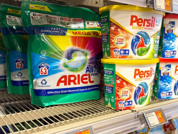 Süpermarket rafında ariel ve persil dolu çamaşır deterjanı paketleri.