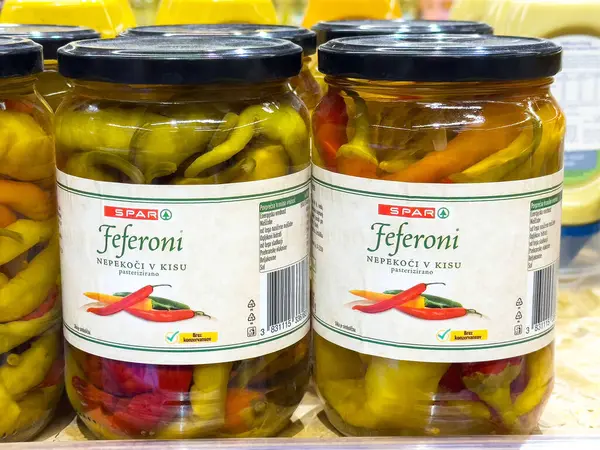 Kavrulmuş biber turşusu: marketin rafında canlı sarı ve kırmızı feferoni..