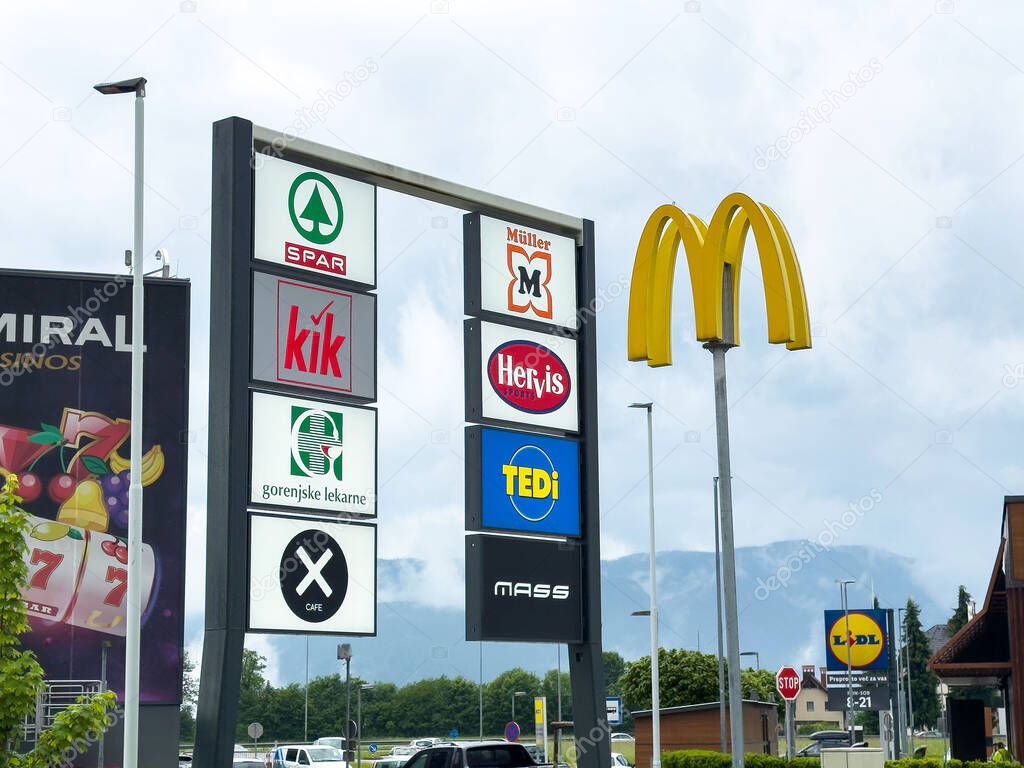 Outdoor shopping center sign with popular retail and food brand logos.