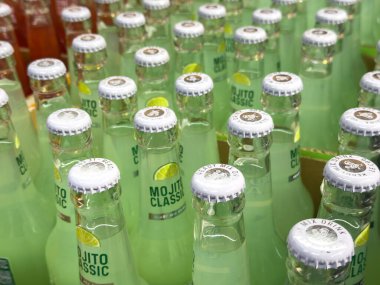 Kapağında taze limon tasarımı olan çeşitli mojito şişeleri..