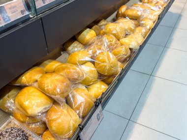 Marketin rafında taze pişmiş ekmek ruloları sergileniyor..