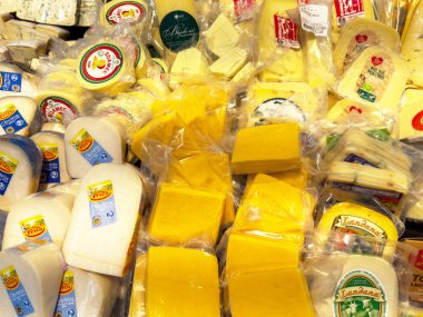 Etiketleri ve farklı dokuları olan paketlenmiş peynirlerin çeşitliliği.