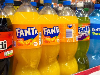 Renkli fanta portakalı, sıfır şeker ve rafta egzotik içecek şişeleri var..