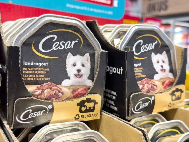 Markette Asyalı kadın çocukla Cesar köpek maması ambalajlama.