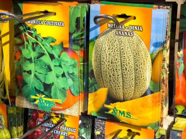 Bir mağazada çeşitli sebze ve kavun tohumu paketleri sergileniyor.