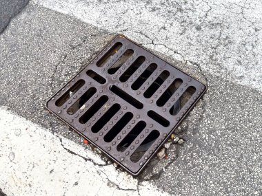 Kırık asfalt yol yüzeyinde metal akıntısı olan şehir kaldırımı..