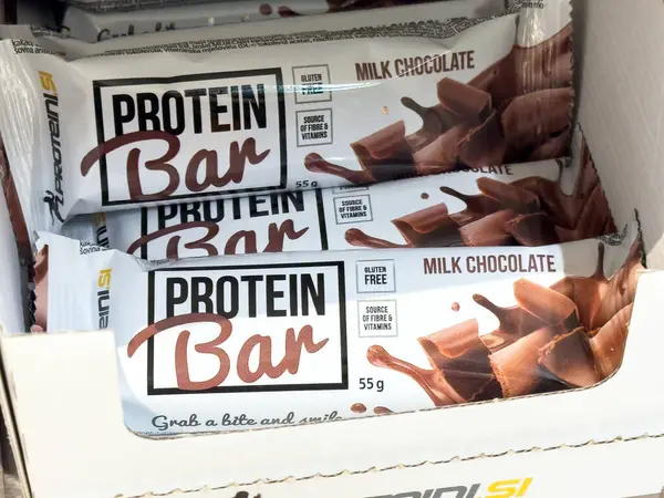 Kutuda gösterilen ambalajda süt çikolatalı protein çubukları.